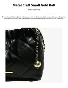Detail of black quilted bucket bag featuring a detachable strap and gold ball charm