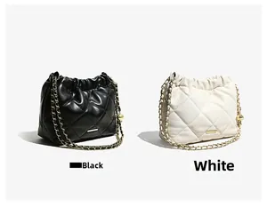Detail of quilted bucket bags in black and white with chain straps and metal charms
