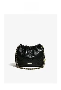 Detail of black quilted leather bucket bag with gold chain strap and drawstring closure