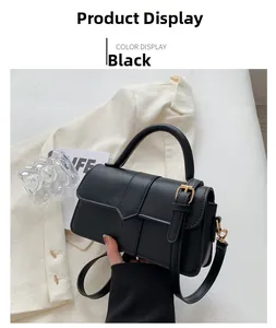 Detail of black matte leather handbag with golden hardware and elegant V-shaped flap