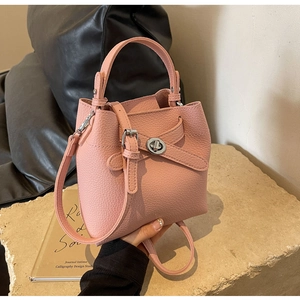 Nahaufnahme der rosa Eimer-Tasche aus Litschileder mit Silberverschluss auf Stein