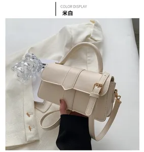 Detail of off-white crossbody bag with envelope flap and adjustable buckle strap