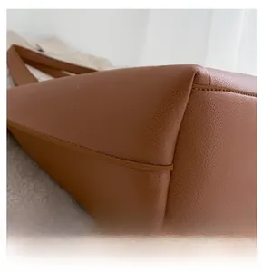Détail macro du cuir grainé marron de haute qualité et coutures précises sur le sac fourre-tout