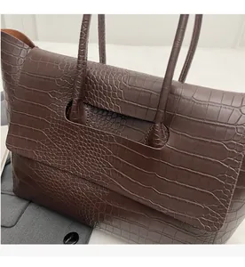Close-up of retro dark brown tote bag featuring detailed crocodile pattern embossing