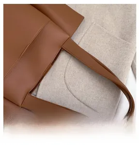 Détail du cabas en cuir grainé marron foncé avec poignées renforcées à double surpiqûre