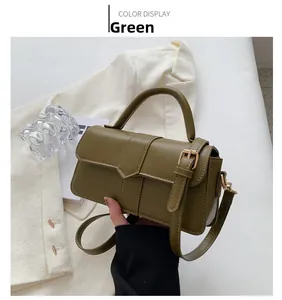 Detail of olive green handbag featuring a rectangular flap and metallic buckle hardware