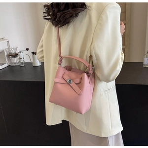 Detailansicht der rosa Eimer-Tasche aus strukturiertem Leder mit silbernem Drehverschluss