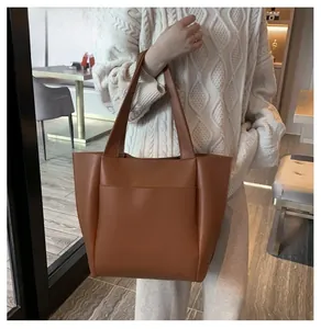 Vue détaillée du sac cabas en cuir marron avec grande poche avant dans un cadre élégant