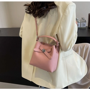 Detailansicht der rosa Eimertasche mit Litschi-Muster, Drehverschluss und Riemen