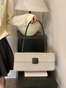 Detail of cream woven baguette bag with brown straps and vintage buckle design
