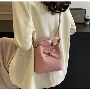 Details einer rosa Beuteltasche mit Kugelverschluss und Kreuzriemen in der Seitenansicht