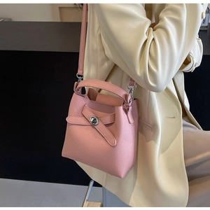 Nahaufnahme einer rosa Lederbeuteltasche mit silbernem Schloss und Schultergurt