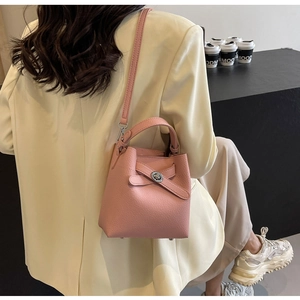 Detail der rosa Bucket Bag aus genarbtem Leder mit silbernem Drehverschluss und Griff