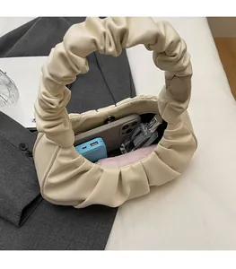 Interior detail of creamy cloud bag showing storage for phone, perfume and accessories