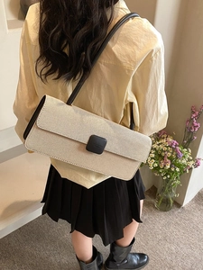 Detailed close-up showing the elegant beige woven texture and black leather strap of the bag