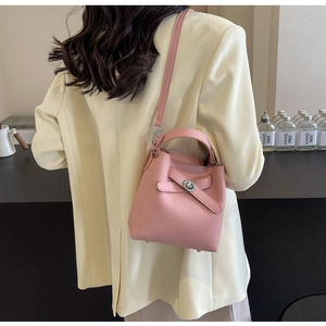 Detail der rosa Bucket Bag aus genarbtem Leder mit Griff und elegantem Drehverschluss