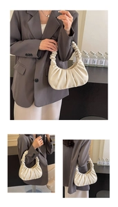 Detail of the gathered cloud pleats and soft vegan leather texture on this cream hobo bag