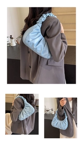Detail of light blue pleated cloud crescent bag showing texture and stylish shoulder strap