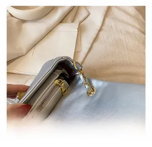 Macro shot of silver quilted leather bag with gold chain and burgundy interior lining