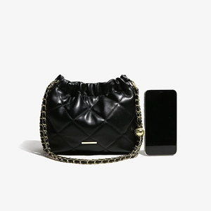 Elegant black quilted bucket bag with golden chain strap and leather woven details