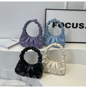 Four cloud-style ruched leather bags in purple, blue, black, and beige on steps