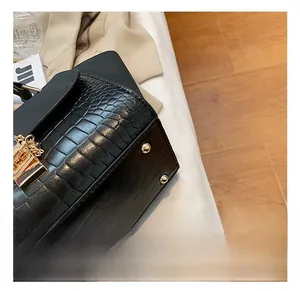 Close-up of black crocodile texture handbag with premium gold hardware and sturdy metal studs