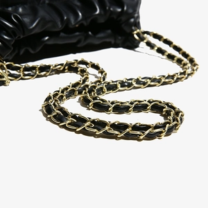 Quilted black leather bucket bag with gold chain strap shown on a clean white background