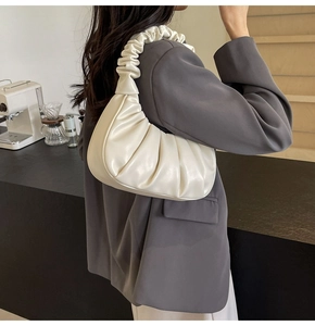 Detail of white pleated cloud shoulder bag with premium leather texture for women