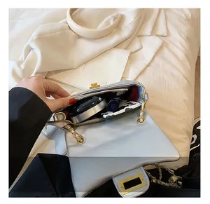 Detailed interior of a quilted silver shoulder bag showing storage for makeup and phone