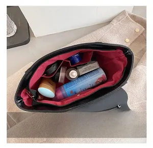Detail view of the black matte handbag interior showing red lining and spacious capacity
