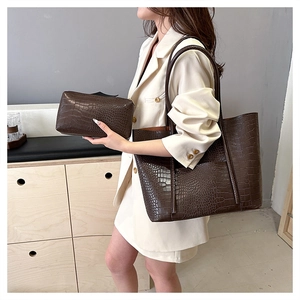 Detail of dark brown crocodile pattern tote bag set including a small clutch pouch
