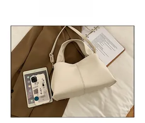 Detailed close-up of cream PU leather tote bag with vertical stitching and wide strap