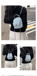 Detail showing the light blue quilted leather texture and silver chain strap on the bag