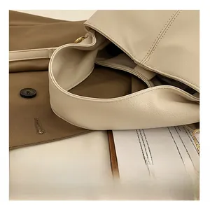 Close-up of cream white lychee texture faux leather handbag with fine stitching and gold hardware
