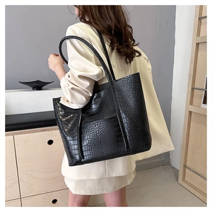 Close-up of black crocodile pattern embossed tote bag with slim shoulder straps