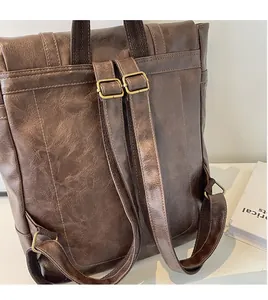 Detail des braunen Vintage-Rucksacks mit verstellbaren Trägern und goldenen Metallschnallen