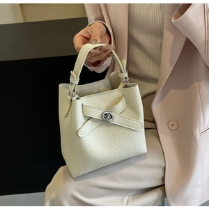 Detailansicht der cremefarbenen Beuteltasche aus Leder mit Lychee-Muster und Silberverschluss