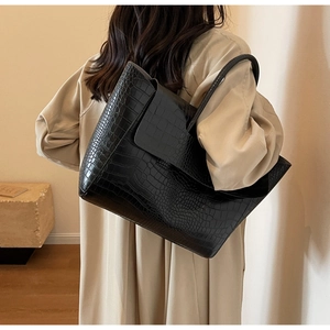 Detail of black faux crocodile leather tote bag with elegant texture for office work