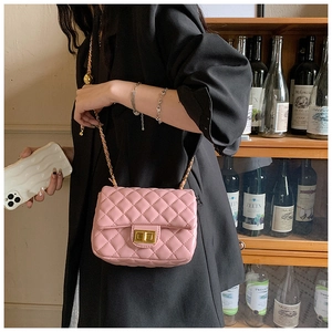 Detail of pink quilted chain bag with gold twist lock and elegant crossbody strap