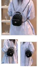 Close-up of black quilted mini backpack with metal chain straps and turn-lock detail