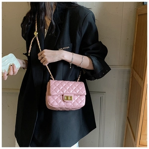 Pink quilted crossbody bag with gold chain strap shown on black blazer suit