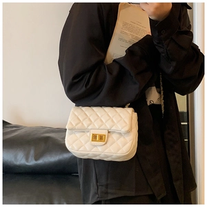 White quilted leather crossbody bag with gold-tone hardware on a fashion model