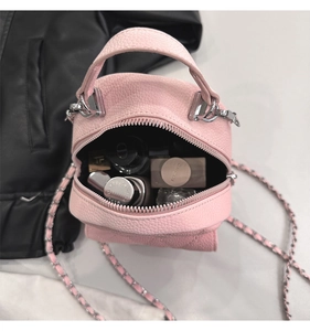 Internal view of pink pebble leather mini bag showing compact storage for cosmetics