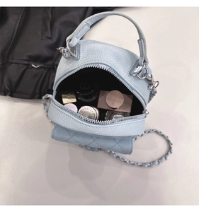 Internal view of mini light blue quilted backpack showing capacity for cosmetics
