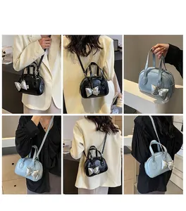 Detailed views of crossbody shell bag with metallic bow pendant and long strap