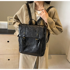 Detailansicht des schwarzen Vintage-Lederrucksacks mit Textur und Bronzeschnallen
