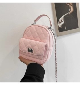 Close-up of pink quilted mini backpack with silver metal twist lock and chain strap