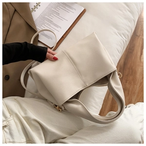 Detail der cremefarbenen PU-Tasche mit Litschistruktur und zwei Trageriemen