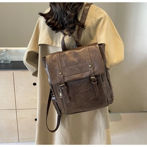 Detail eines dunkelbraunen Vintage-Rucksacks aus PU-Leder mit Schnallen und Griff