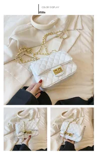 Detail view of white quilted crossbody bag with gold metal clasp and chain strap